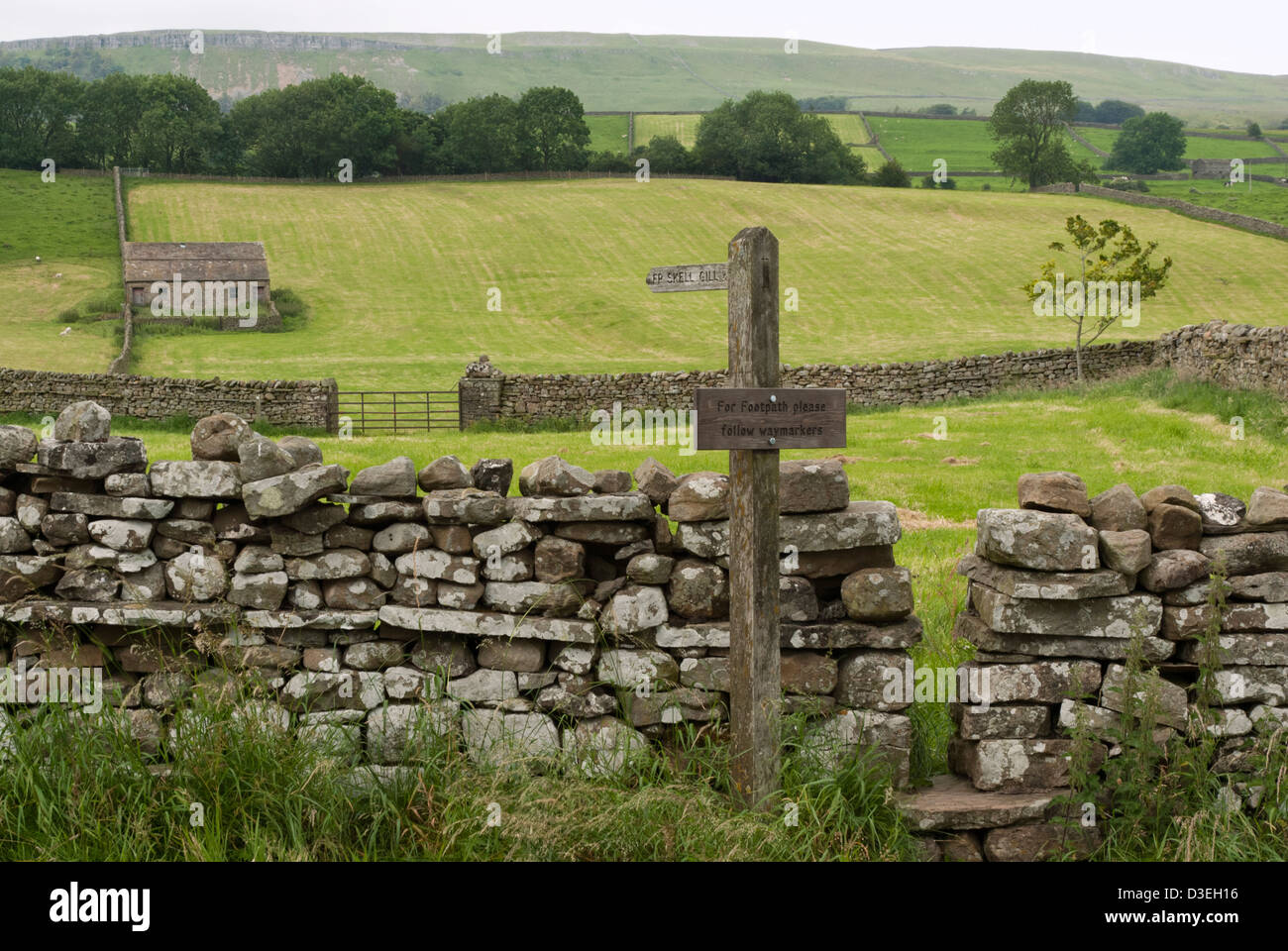 Signposted footpath with gap for passage through dry stone wall to ...