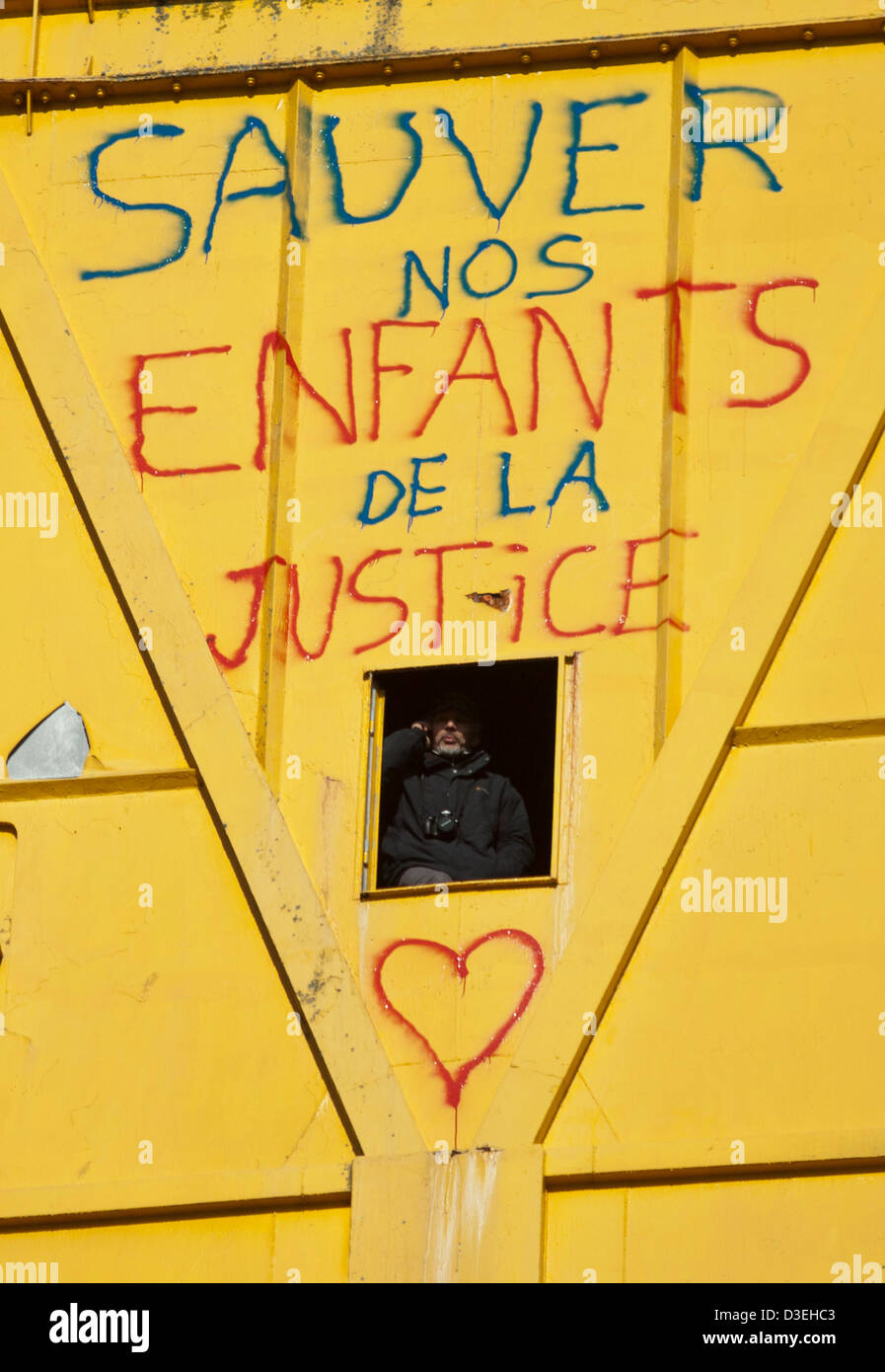 Serge Charnay speaks on his mobie phone from his position in a 40 metre high shipyard crane in Nantes, France, 18 February 2013. Charnay climbed the crane on 16 February to protest a court decision denying him access to his son. Stock Photo