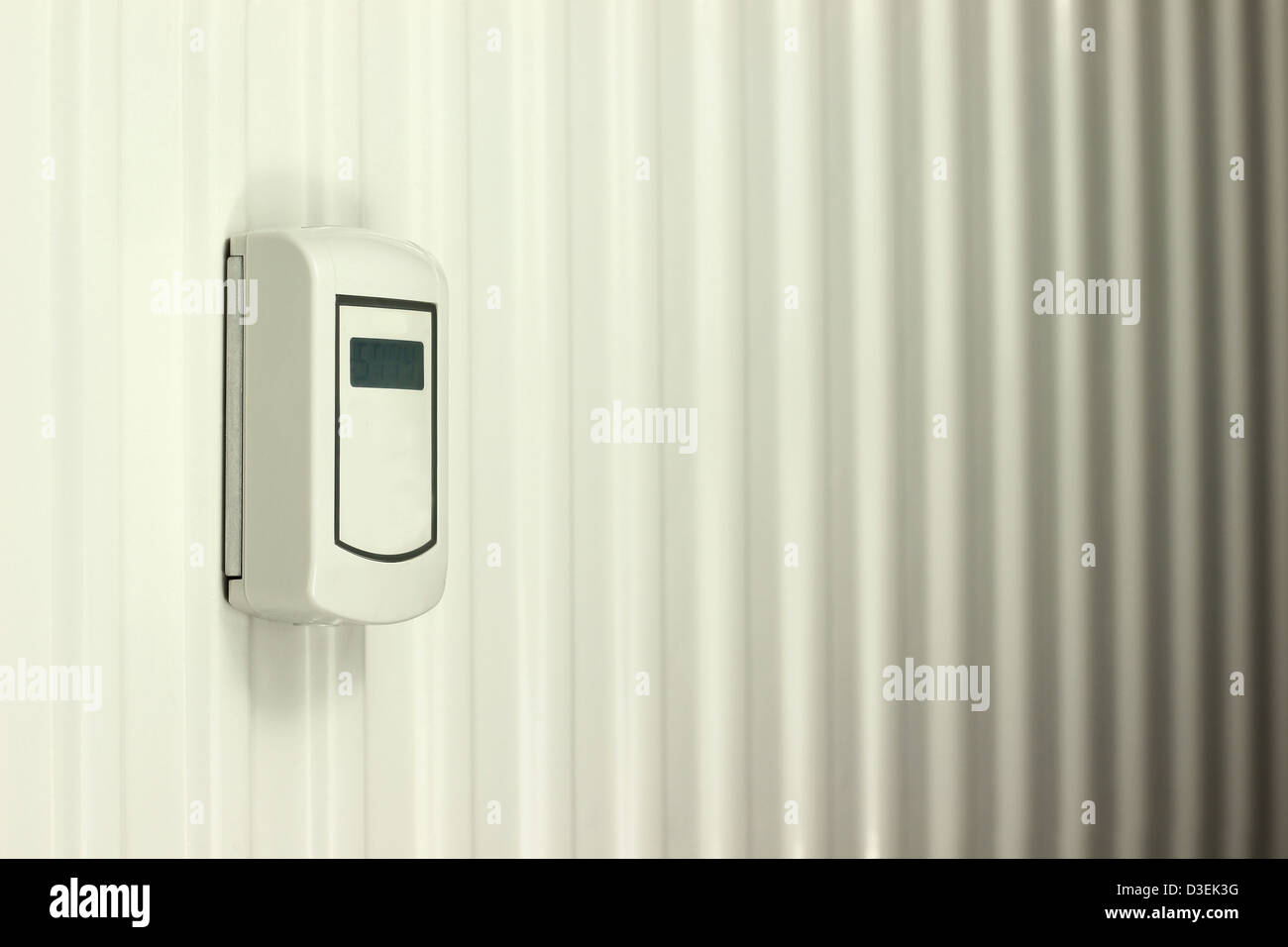 Heat cost allocator on white heater Stock Photo