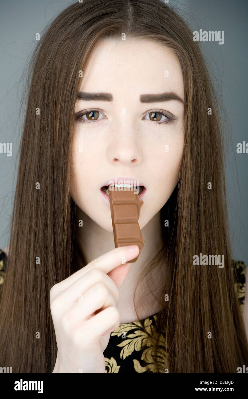 Teenage girl eating chocolate. Stock Photo