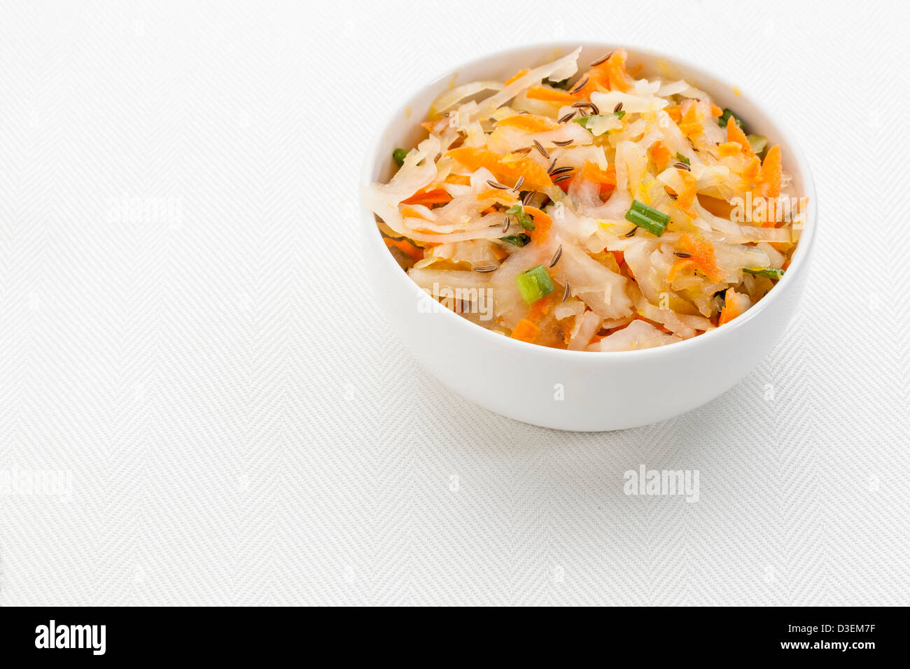 sauerkraut salad with carrot, green onion, caraway and olive oil - a small bowl against white canvas Stock Photo