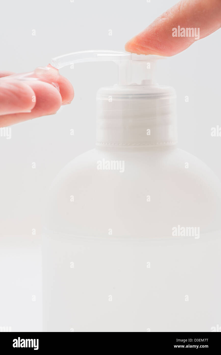 Closeup of bottle containing disinfectant gel and hand of a caucasian man Stock Photo