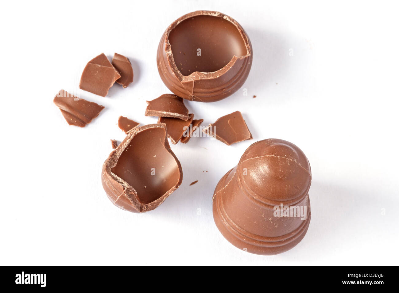 Cracked chocolate bell with another good isolated on white Stock Photo