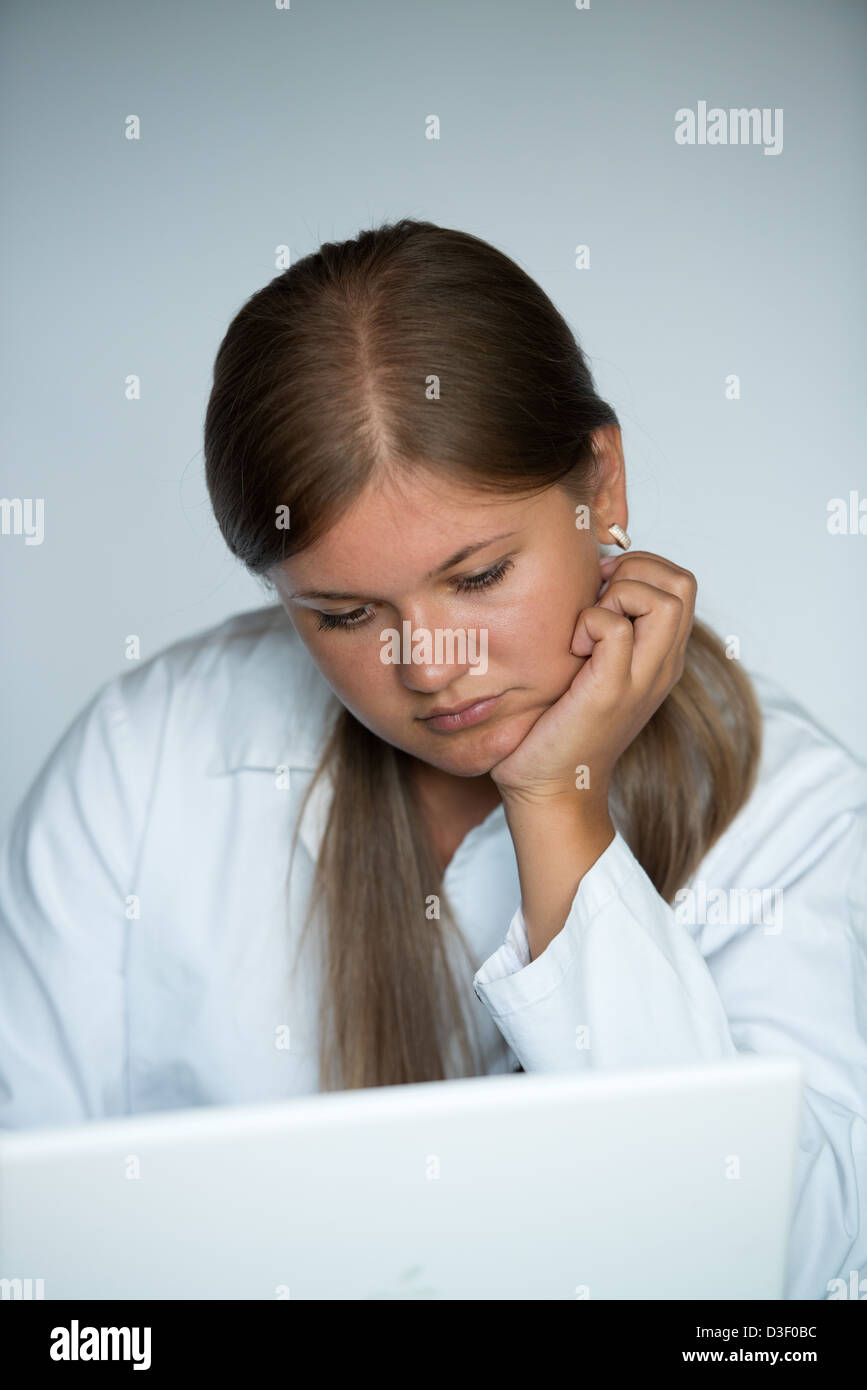 young female doctor in white coat works with laptop Stock Photo - Alamy