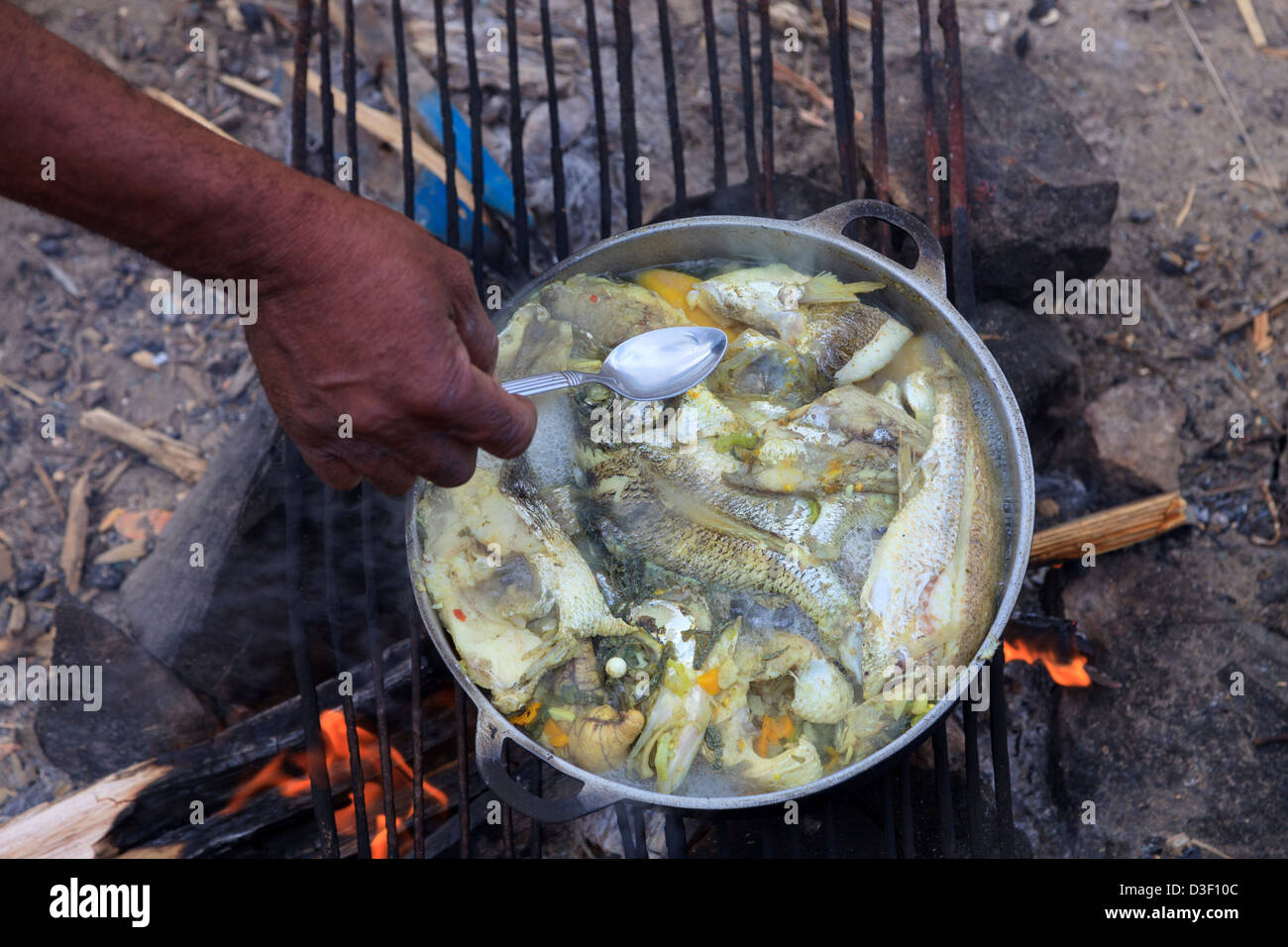 Traditional fish stew being prepared on an open fire by a fisherman at Micoud harbour, St Lucia Stock Photo