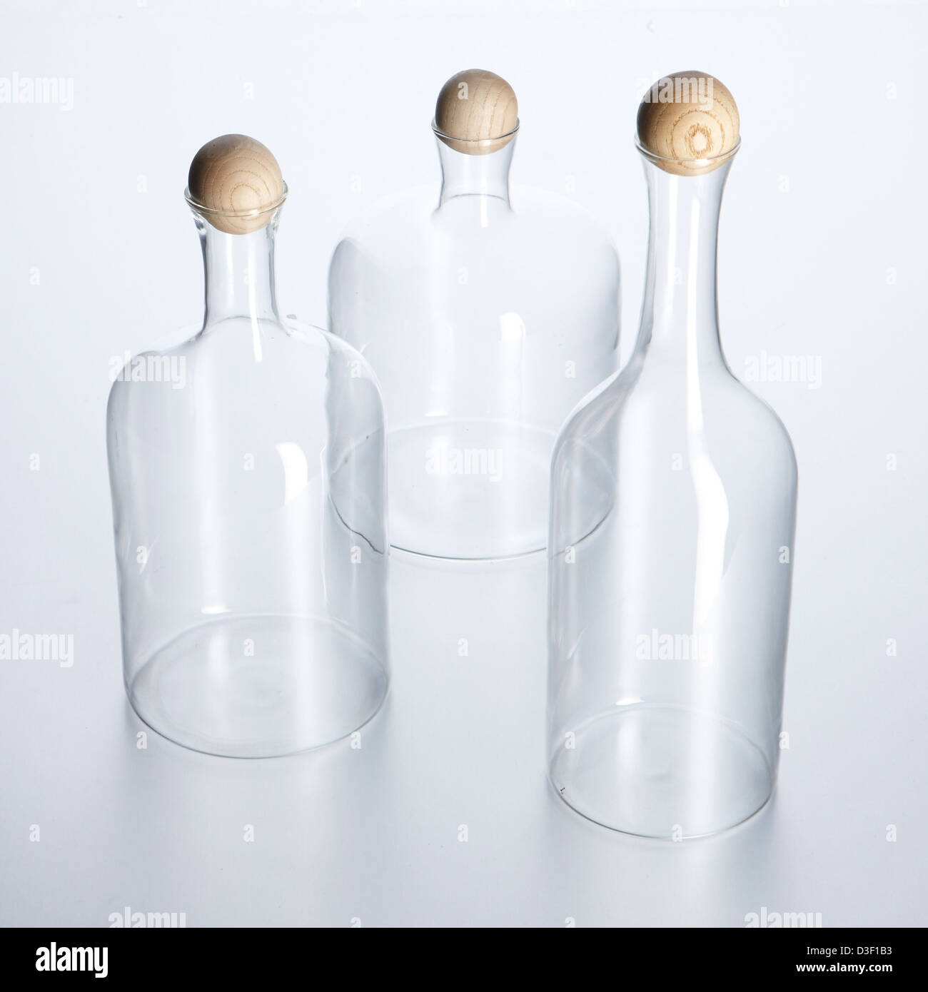 three glass decanters wooden ball stoppers Stock Photo