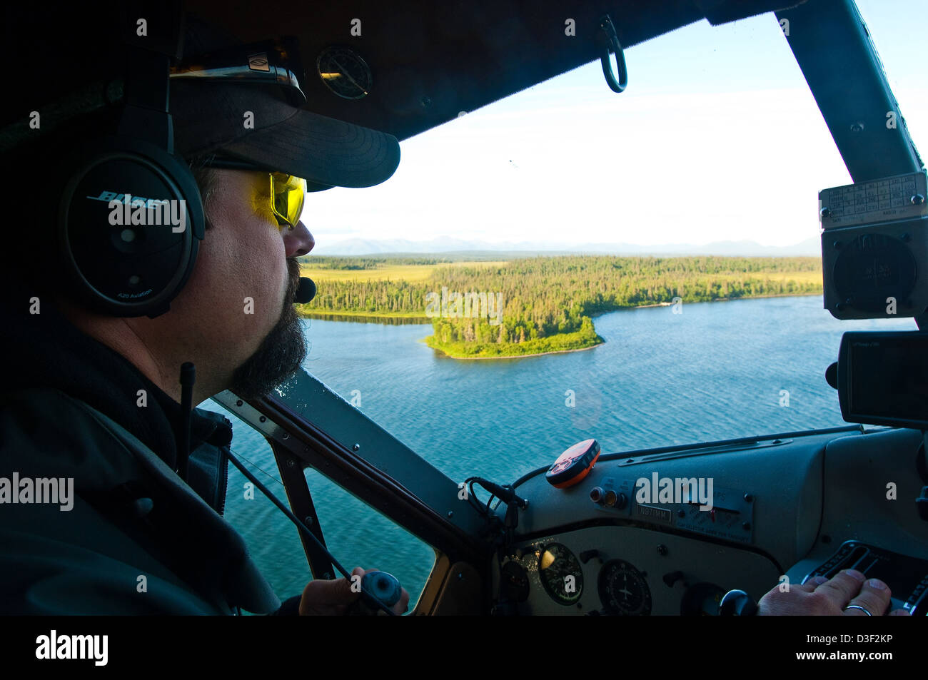 Pilot flying DeHavilland Beaver floatplane over forest and lakes, near Dillingham Alaska Stock Photo