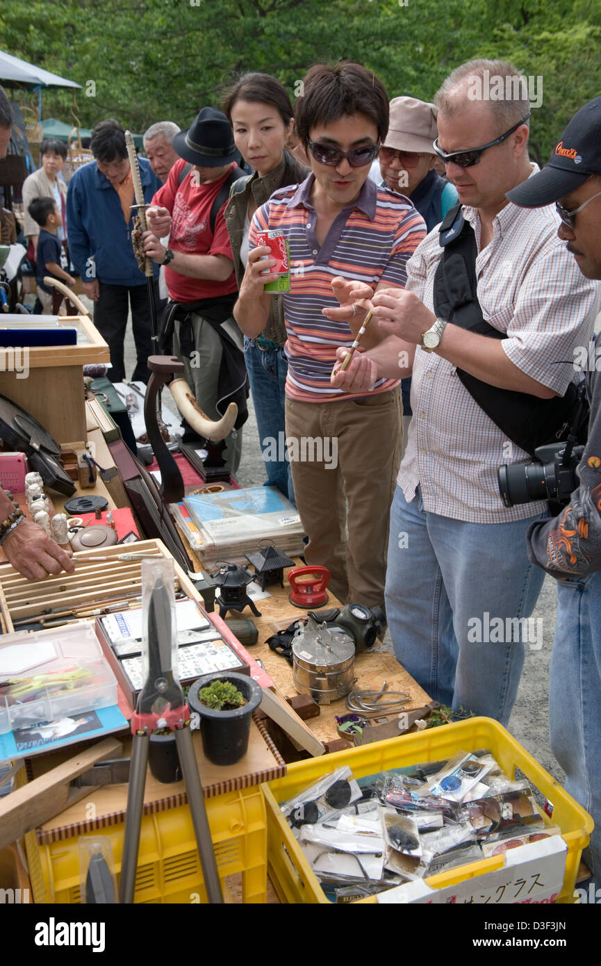 Foreigners pick through treasures and junk at an outdoor flea market in Odawara, Kanagawa, Japan. Stock Photo