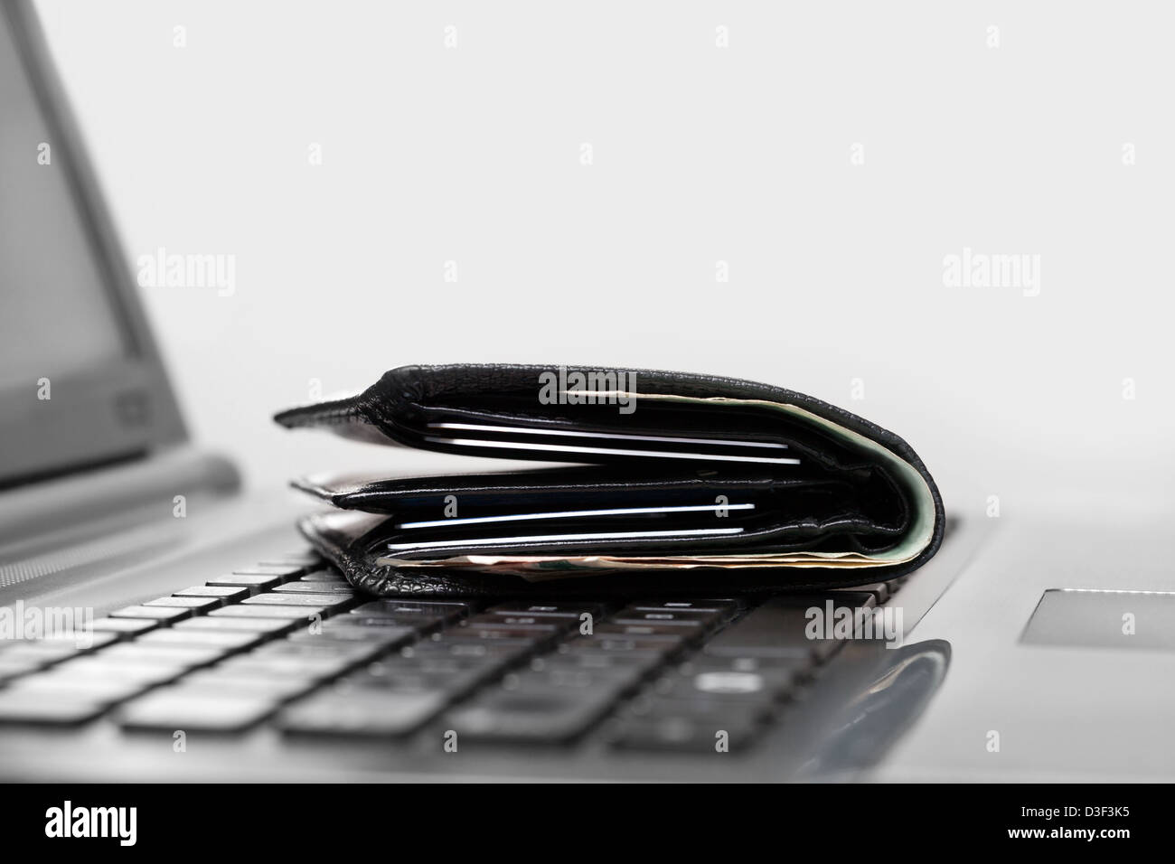 Wallet on laptop keyboard Stock Photo - Alamy