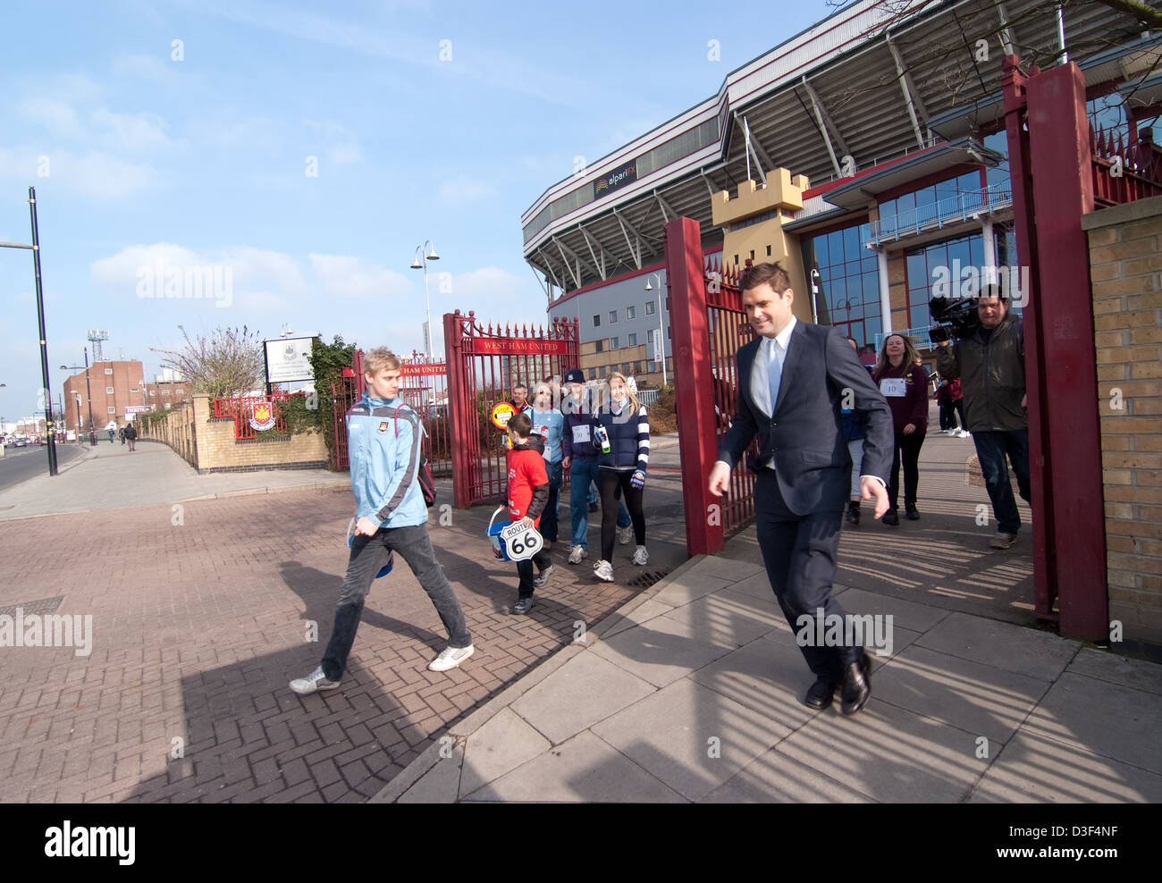 TV reporter and his film crew hurry to get ahead of Jonjo Heuerman as he leaves Upton Park on his ROUTE66 sponsored walk Stock Photo