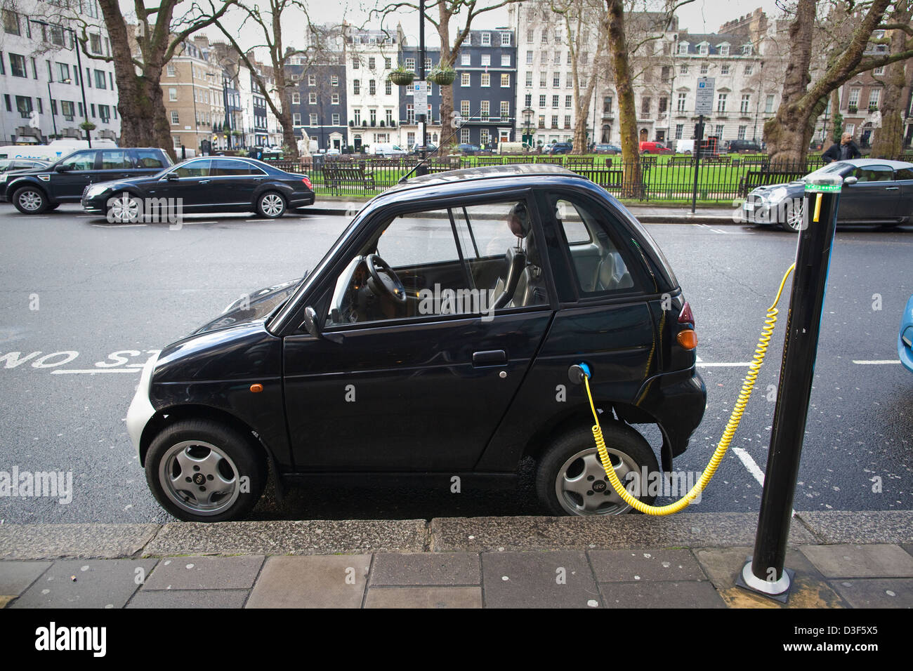 G Wiz Reva electric car parked at charging bay, Berkeley Square, London, England, UK Stock Photo
