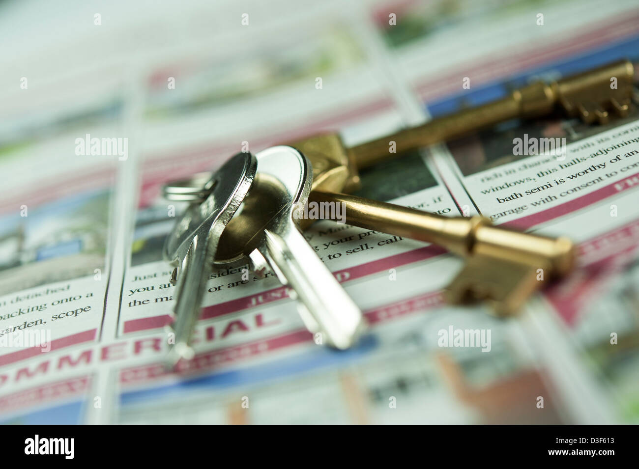 Close up, macro, micro photograph of house keys on advertisements of properties for sale. Conceptual Estate Agents photograph. Stock Photo