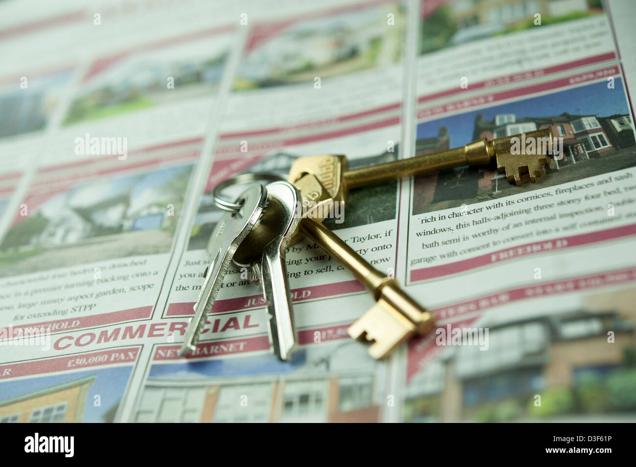 Close up, macro, micro photograph of house keys on advertisements of properties for sale. Conceptual Estate Agents photograph. Stock Photo