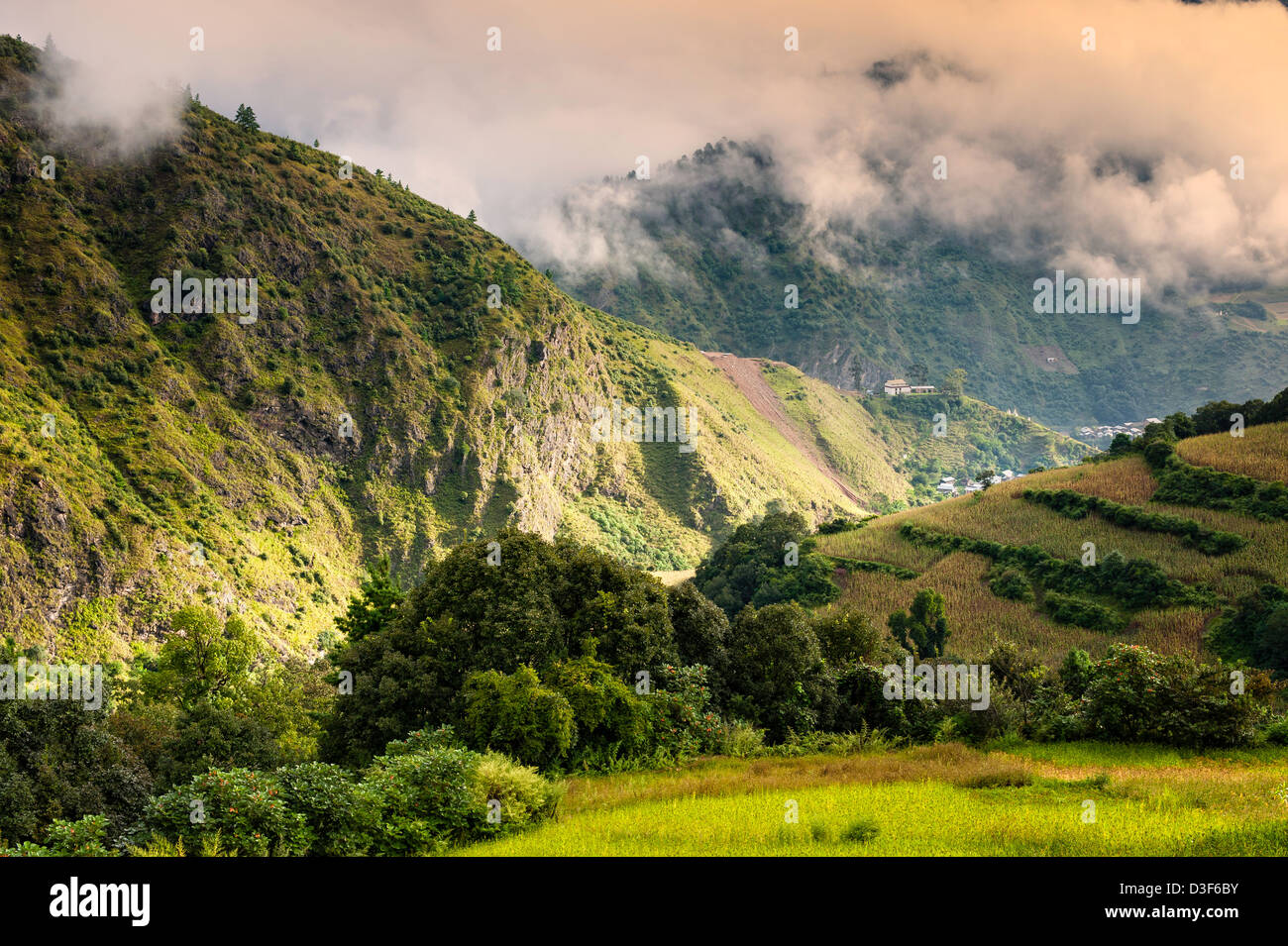 Mountains in western Arunachal Pradesh at dawn. The peaks are shrouded in cloud but the sunlight is breaking through. Stock Photo