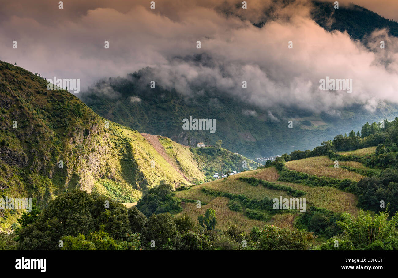 Mountains in western Arunachal Pradesh at dawn. The peaks are shrouded in cloud but the sunlight is breaking through. Stock Photo