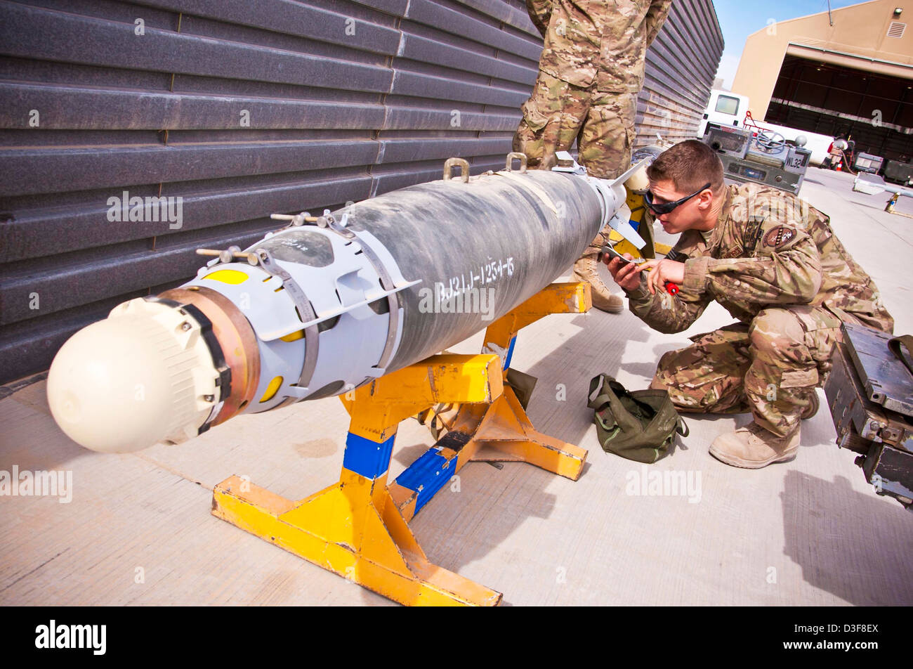 A US Air Force airman inspects a GBU-38 bomb before being loaded on a fighter aircraft February 11, 2013 at Kandahar Airfield, Afghanistan. Stock Photo