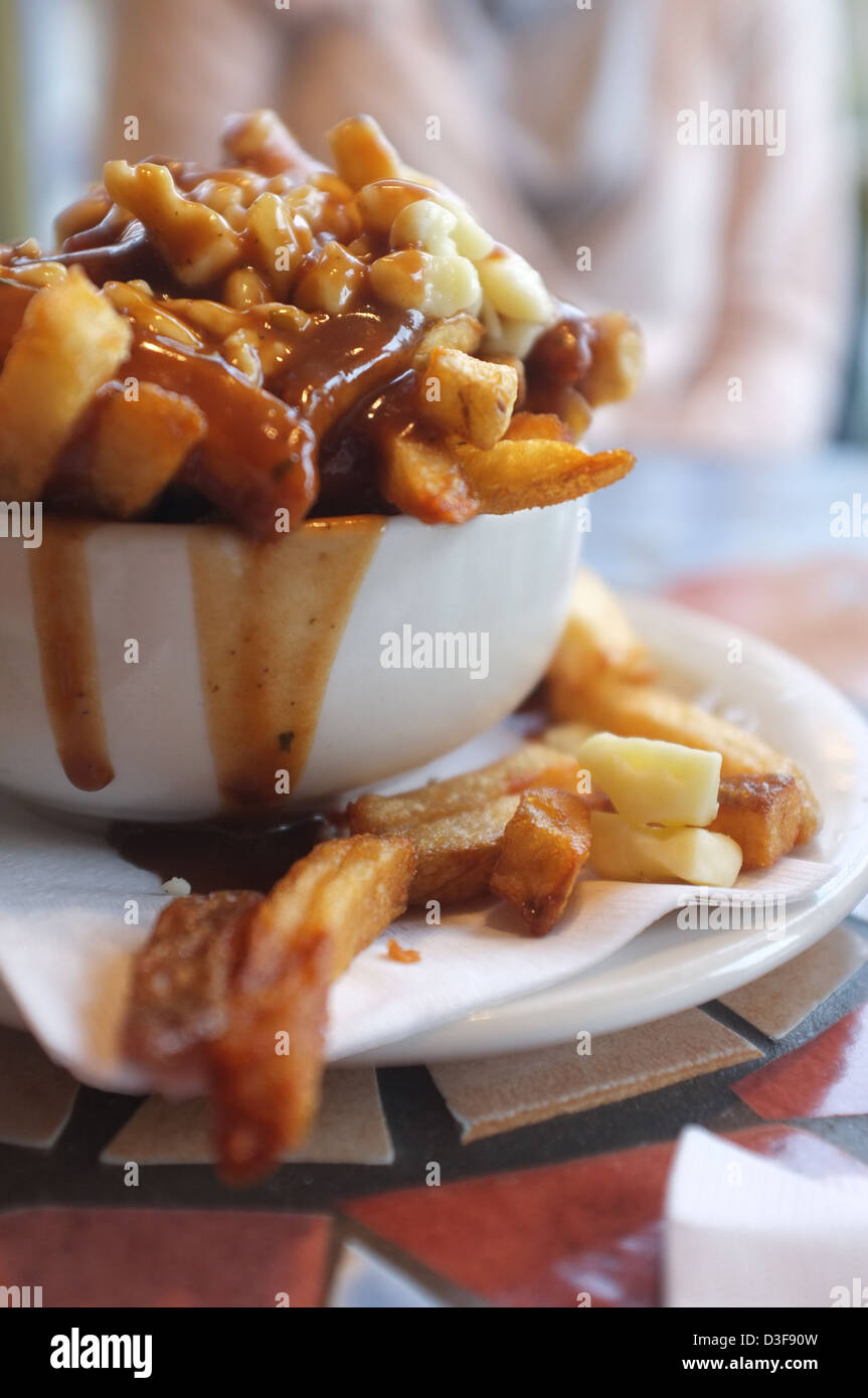 Poutine is a fast food that originated in Quebec, Canada Stock Photo