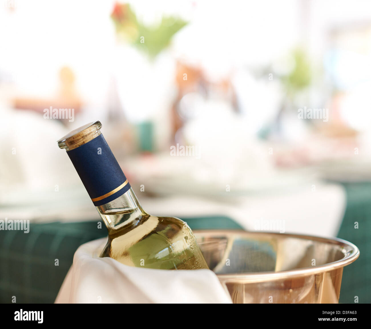 Bottle of cold white wine in ice on restaurant table Stock Photo
