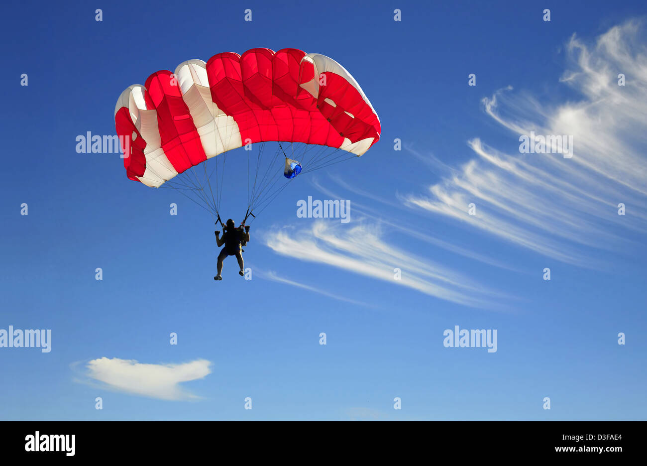 Red parachute landing on blue sky Stock Photo - Alamy