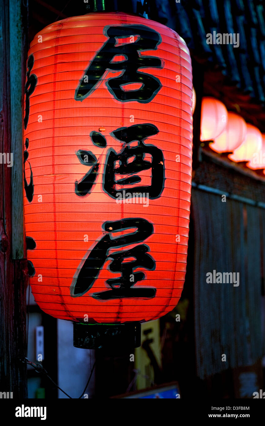Red chochin paper lantern with kanji characters 'Izakaya,' casual drinking establishment popular with after-work crowd in Japan Stock Photo