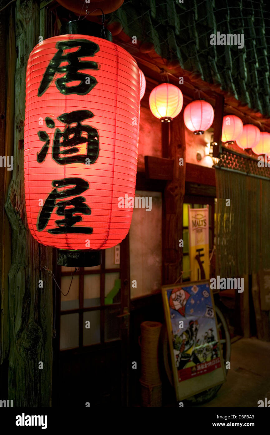 Red chochin paper lantern with kanji characters 'Izakaya,' casual drinking establishment popular with after-work crowd in Japan Stock Photo