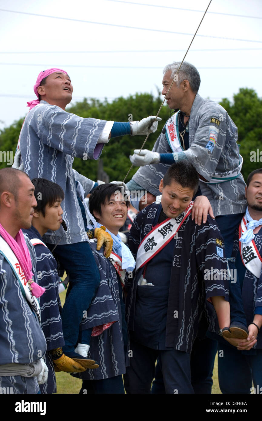 Kite flying team of men hold line at Hamamatsu Takoage Gassen, annual