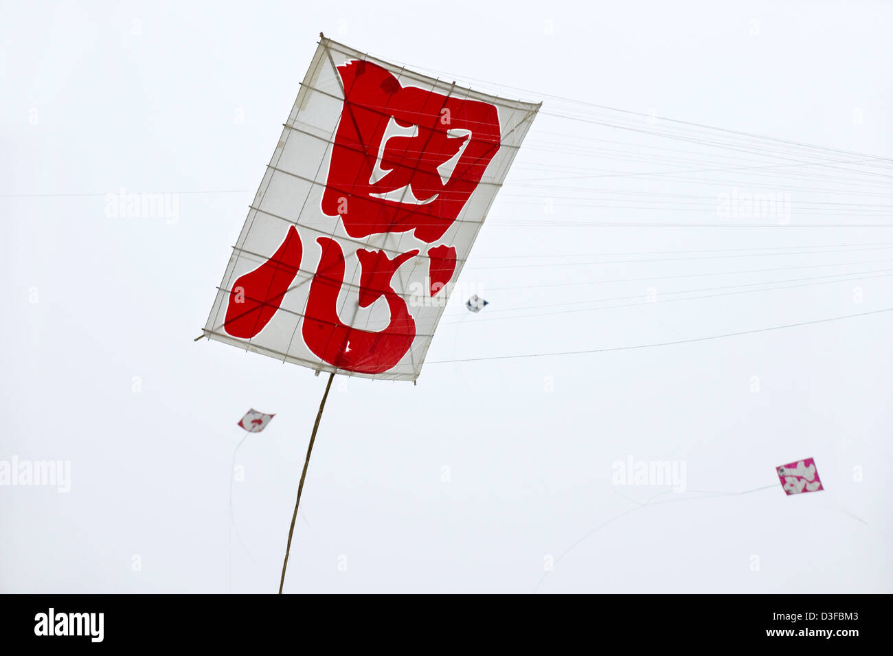 Colorful traditional paper and bamboo kites soar in wind at Hamamatsu Takoage Gassen Kite Fighting Festival in Hamamatsu, Japan Stock Photo