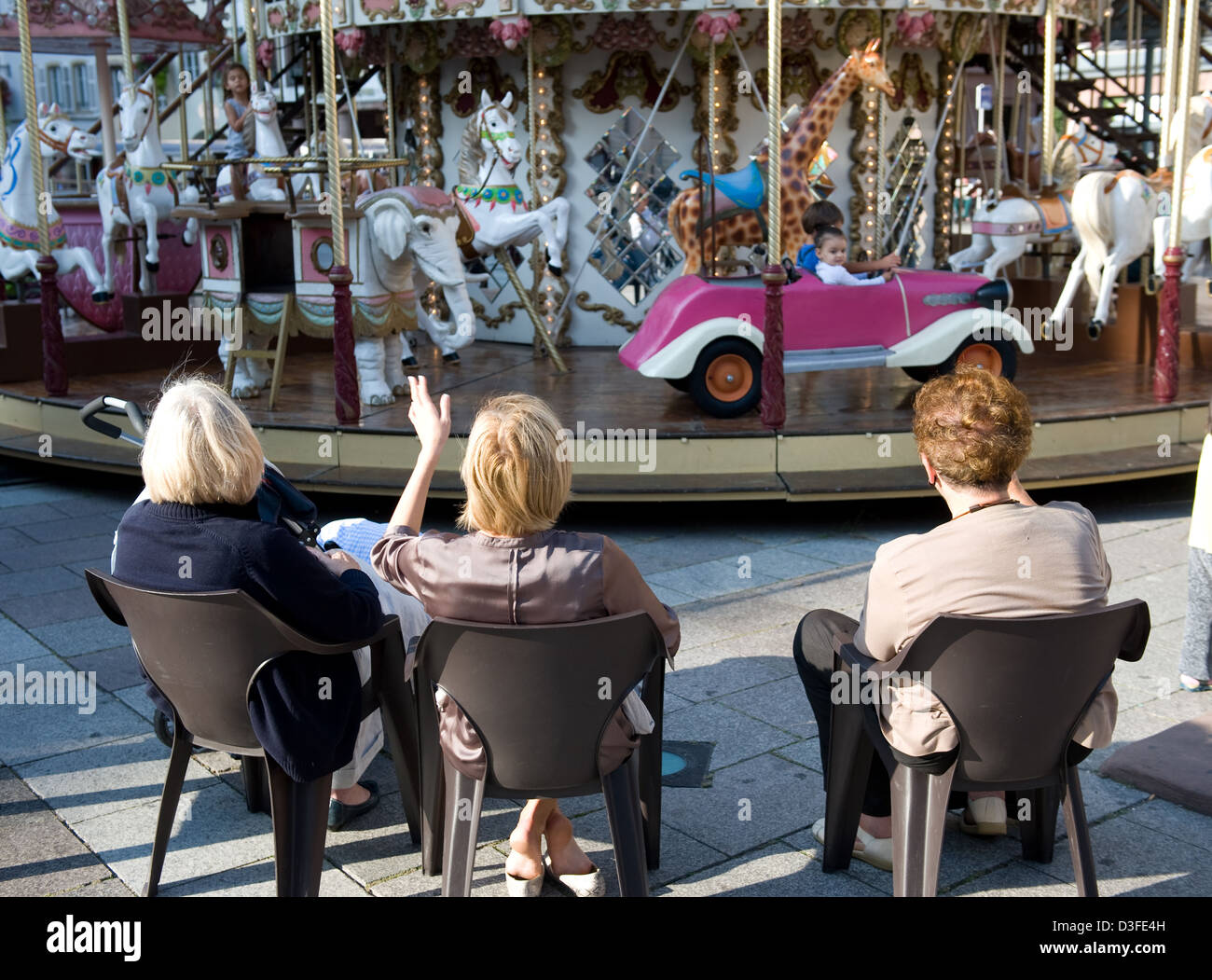 Strasbourg, France, women sit in front of a children's carousel Stock Photo