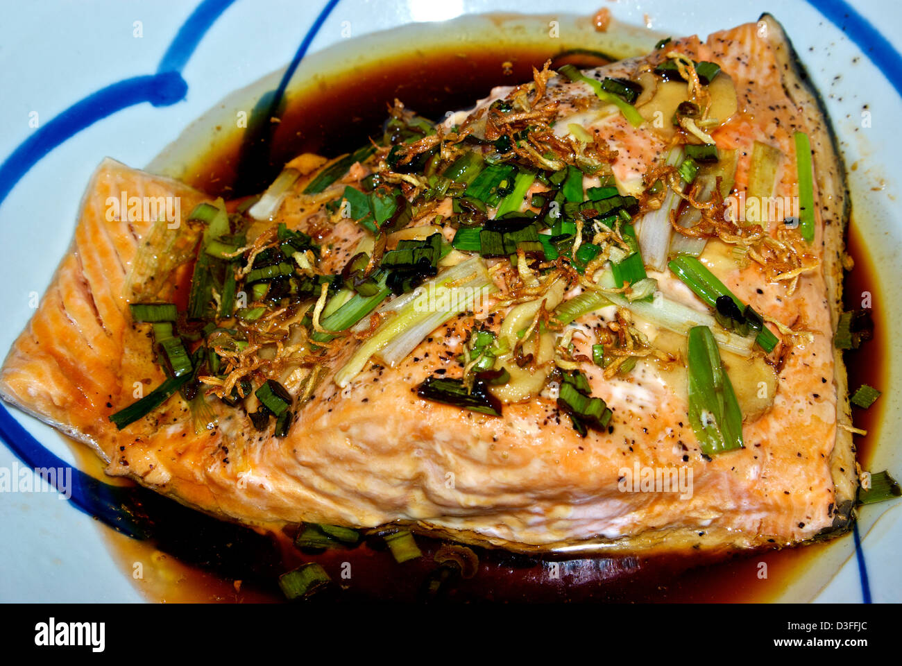 Steamed Asian style fish fillet green onion fried ginger slivers soya sauce Stock Photo