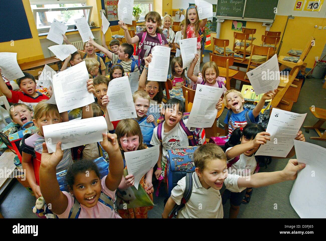 (dpa) - Students of 1st grade present their final year's certificate in their classroom at the Schenckendorff elementary school cheer in Koblenz, Germany, 18 July 2003. Six weeks of untroubled summer holidays lie in front of them. Stock Photo