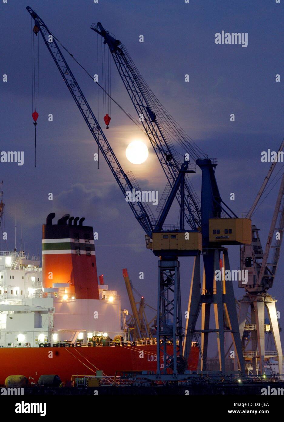 (dpa) - Full moon rises above three loading cranes and an illuminated freigther at a dock yard in the harbour in Hamburg, Germany, 12 July 2003. Economic prospects in the Euro area remain bleak for the short-term. According to projections by the European commission the economic growth in the Euro area, which consists of 12 national economies, will only grow marginally. Guesses are  Stock Photo