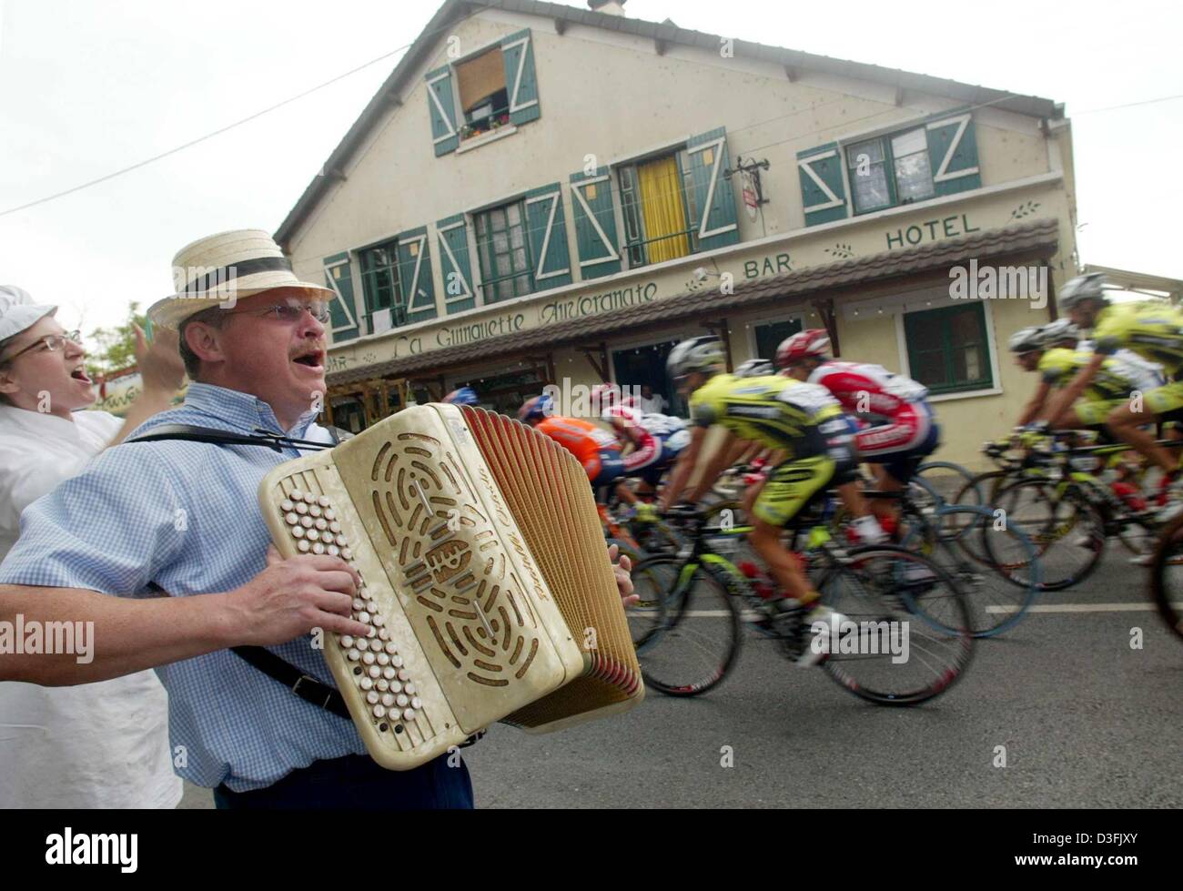 (dpa) - The pack of cyclists are cheered up by accordion players in a street of a village near Paris, 6 July 2003. The first stage of the Tour de France led from the Paris suburb of Montgeron to Meaux over a distance of 168 km. Stock Photo