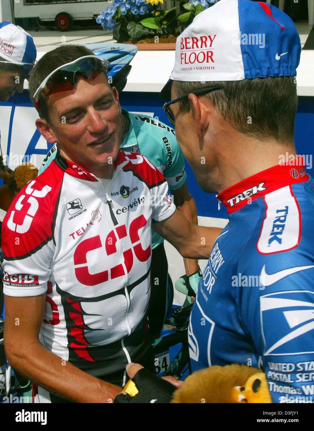 (dpa) - US cyclist Tyler Hamilton (L) of the team CSC Tiscali chats with his fellow countryman and his former team captain Lance Armstrong of the team US Postal Service ahead of the second stage of the Tour de France, in La Ferte-sous-Jouarre, France, 7 July 2003. The previous day Hamilton was involved in a mass accident just before the finish line and suffered a broken collarbone. Stock Photo