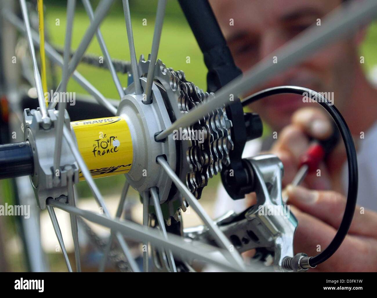 (dpa) - Werner Lenk, mechanic of Team Bianchi, adjusts the gear settings of a racing bicycle a day before the start of the Tour de France in Paris, France, 4 July 2003. The axis of the bicycle which was esspecially built for the race has the logo of the Tour de France attached on it. The Tour de France will start on 5 July 2003 with a prologue in Paris due to the 100th anniversary  Stock Photo