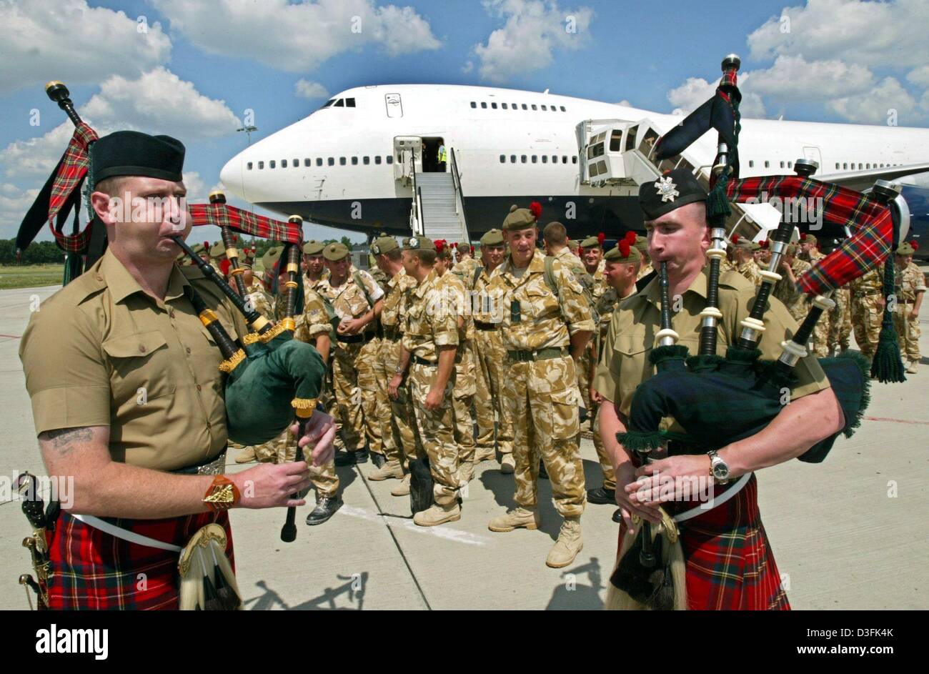 (dpa) - The so-called Desert Rats are welcomed by two pipers at the airfield in Hanover, Germany, 27 June 2003. About 330 British soldiers returned from Iraq to their base in the German state of Lower Saxony. Altogether, about 12,000 troops which are stationed in Germany were fighting in Iraq. They are completely to withdraw from Iraq by mid-July. Stock Photo