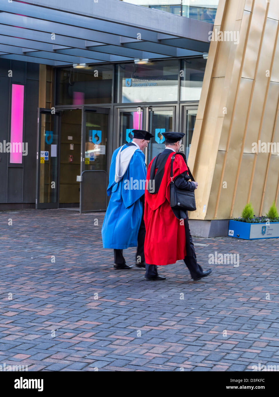 New graduates on graduation day wearing caps and gowns around the campus of University of Sheffield South Yorkshire England Stock Photo