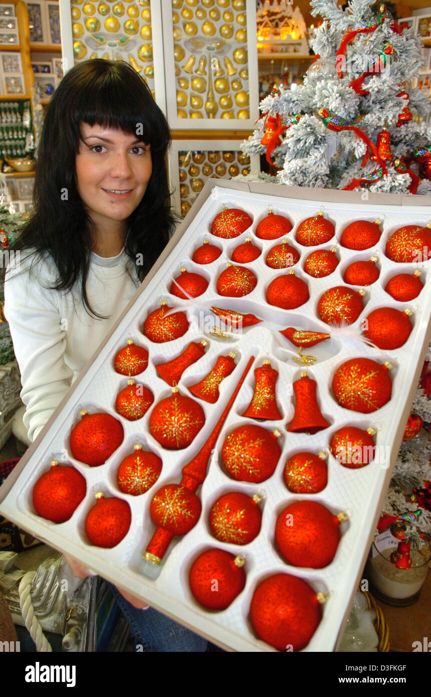 (dpa) - Yvonne Zetzmann presents a set of Christmas tree decoration at the 'Der Christbaum' company in the town of Neuhaus am Rennweg, Germany, 15 December 2004. It is believed that in 1848 a poor glassblower from Thuringia invented the Christmas tree balls. Lacking real apples and nuts which were usually used as decoration for Christmas trees the glassblower instead applied his se Stock Photo