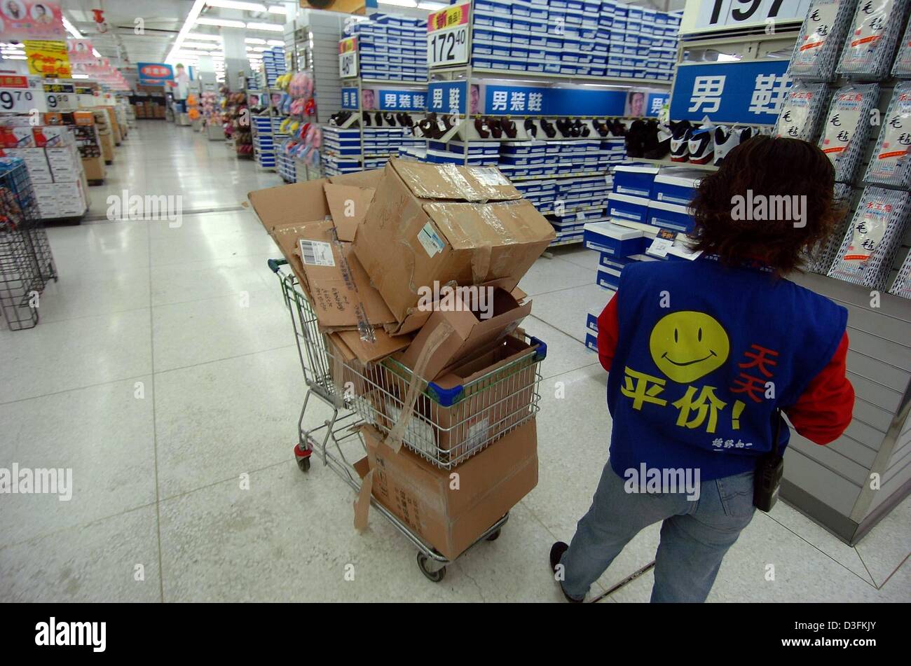 (dpa) - An employee of the Wall Mart supermarket chain fills the shelves in Changchun, China, 7 December 2004. Stock Photo