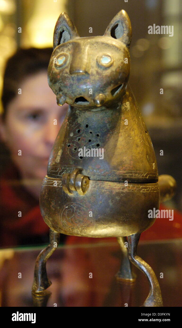 (dpa) - A museum employee looks at an incense container from 11./12. century b.c. at the German Bergbaumuseum in Bochum, Germany, 10 December 2004. The piece is part of the exhibition 'Persia's Ancient Splendour' which is the first such exhibition about Iran and features many pieces never seen before in Europe. The exhibition is held until 29 May 2005. Stock Photo