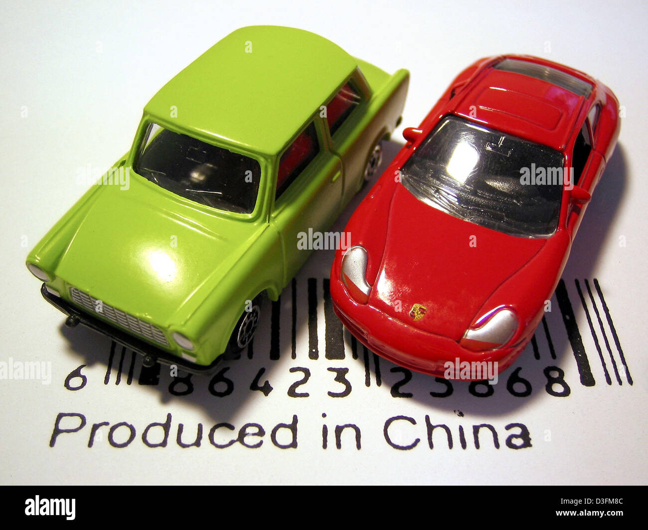 (dpa) - A green Trabant 601 car and a red Porsche Carrera 911 stand on a barcode which indicates that the toy cars were 'produced in China', in Leipzig, Germany, 9 December 2004. The Trabant, nicknamed Trabi, used to be produced in East Germany. China has a 70 per cent market share of the worldwide toy production. Stock Photo