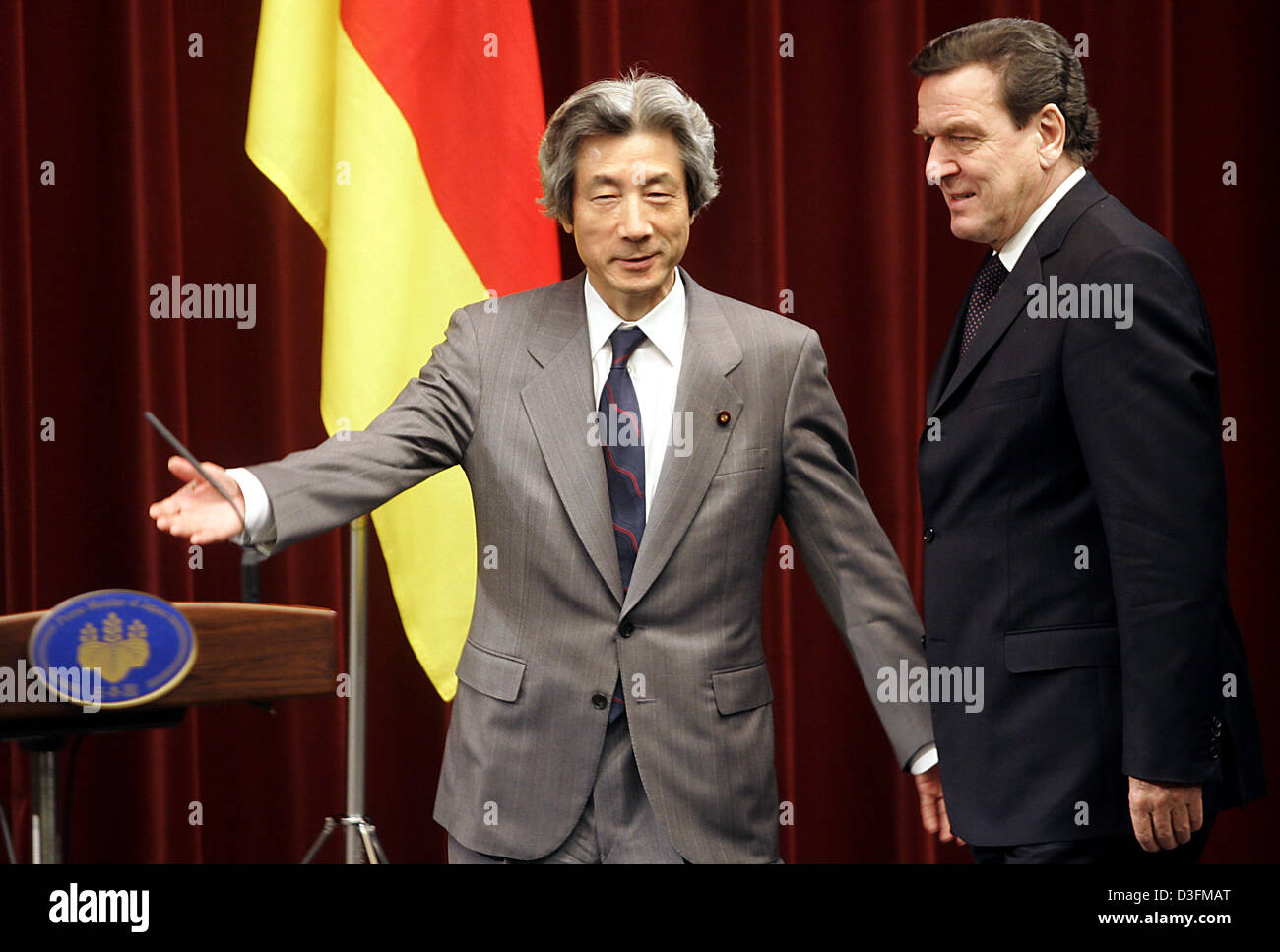 (dpa) - Japanese Prime Minister Junichiro Koizumi (L) shows German Chancellor Gerhard Schroeder the way to a press conference in Tokyo, Japan, 9 December 2004. Schroeder is in Tokyo for a three-day visit. Stock Photo