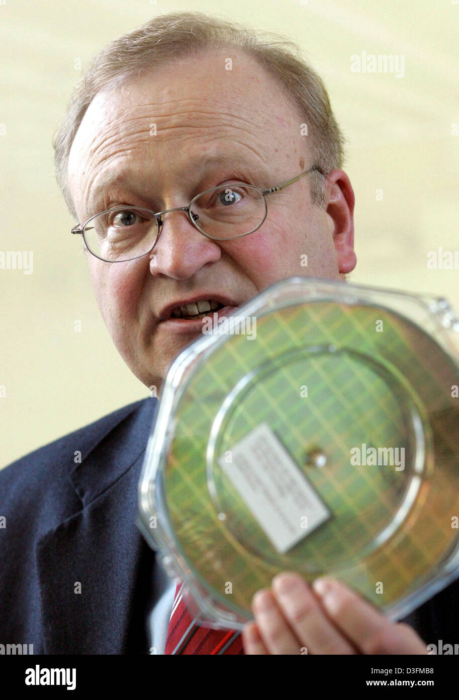 (dpa) - Hans Deppe, Genral Manager of AMD Dresden, holds up a chip wafer during a meeting with the press in Dresden, Germany, Thursday 9 December 2004. In the newly errected AMD Fab 36 plant, 12 months after the start of construction, production machines are being set up and first tests for the production of 300 mm large chip wafers are planned for mid 2005. US computer chip manufa Stock Photo