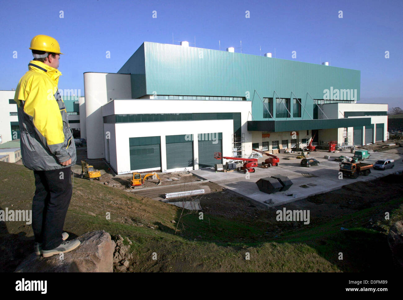 (dpa) - An employee of AMD Dresden looks onto the construction site of the new AMD Fab 36 plant in Dresden, Germany, Thursday 9 December 2004. In the newly errected plant, 12 months after the start of construction, production machines are being set up and first tests for the production of 300 mm large chip wafers are planned for mid 2005. US computer chip manufacturer AMD has inves Stock Photo