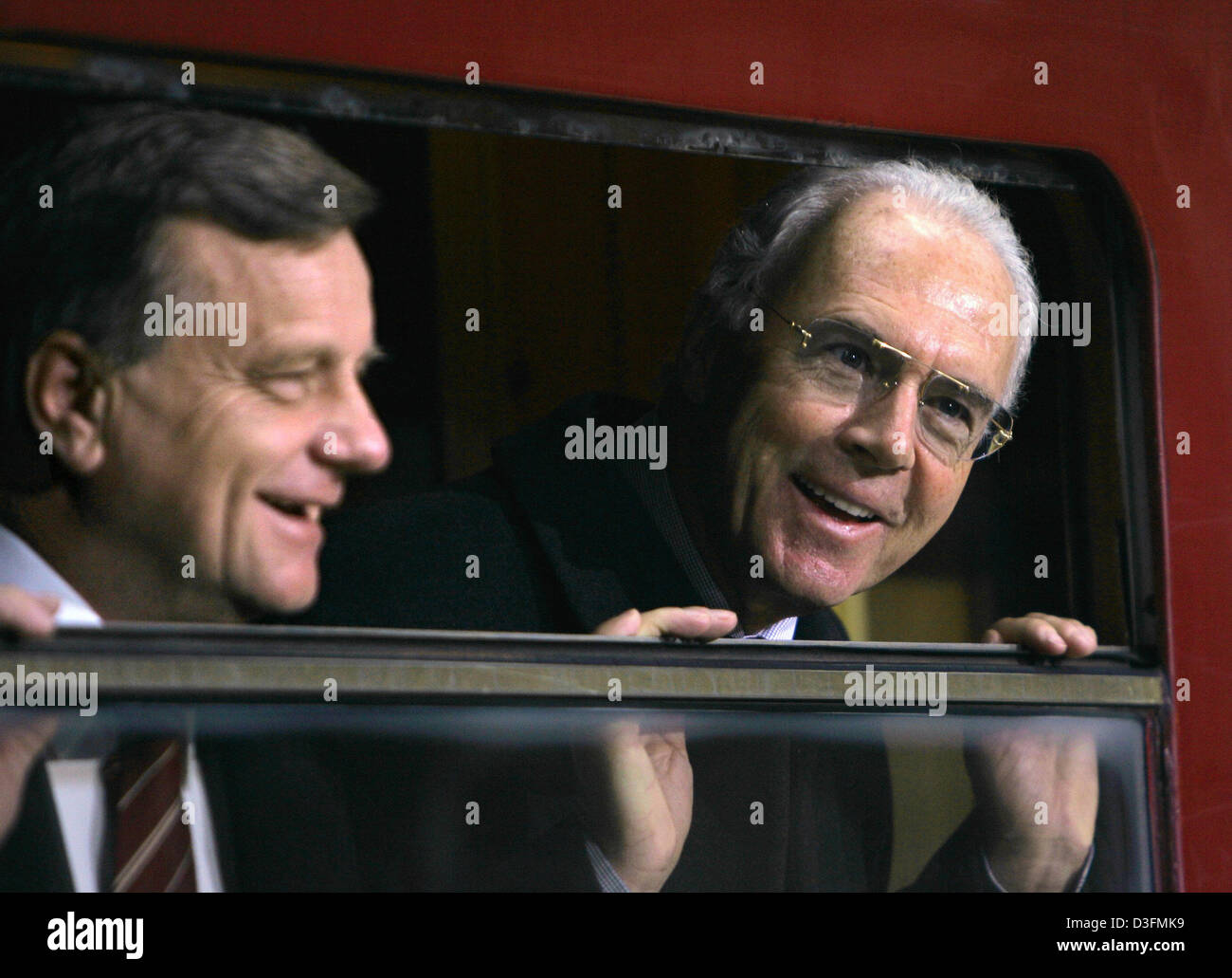 (dpa) - Hartmut Mehdorn (L), chairman of the Deutsche Bahn (DB, German railway), and Franz Beckenbauer, head of the 2006 FIFA World Cup Organizing Committee, look out of a window of the original train with which the first German World Cup winners in 1954 toured the country in Berlin, Germany, 7 December 2004. The Deutsche Bahn has been selected as the final national sponsor for the Stock Photo