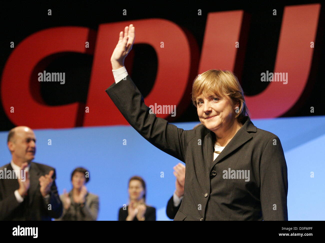 (dpa) - Angela Merkel, Leader of the German Christian Democratic Union (CDU), waves in front of the CDU logo after her speech during the CDU's 18th party congress in Duesseldorf, Germany, 6 December 2004. The party congress takes place under the motto 'Deutschlands Chancen nutzen' (to use Germany's chances). Stock Photo