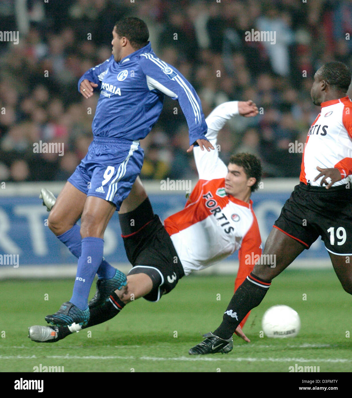 (dpa) - Rotterdam player Karim Saidi (bottom, C) slides into Schalke striker Ailton (L) during the UEFA Cup match between Dutch club Feyenoord Rotterdam and German side FC Schalke 04 at De Kuip Stadium in Rotterdam, the Netherlands, 1 December 2004. Rotterdam won the match 2-1 but both clubs managed to qualify for the last 32 of the UEFA Cup. Stock Photo