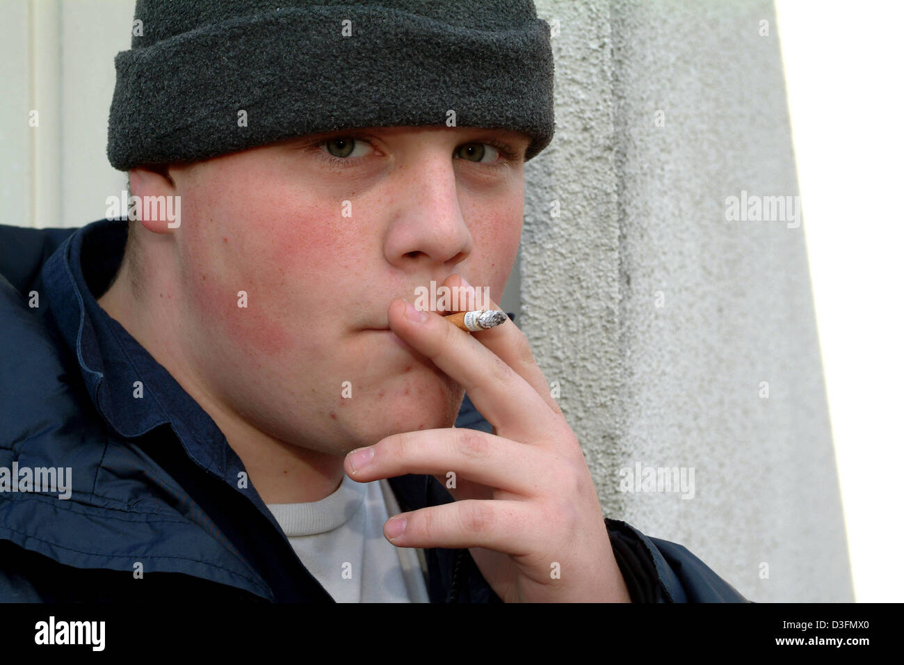 pull cigarette dpa) - A boy pulls on his cigarette during a break on the school yard in  Frankfurt, Germany, 12 October 2004 Stock Photo