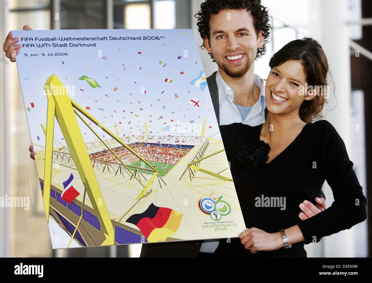 (dpa) - College students Oliver Koetting (l) and Kathrin Winkler present their design which has been chosen as the official FIFA Soccer World Cup 2006 poster for the city of Dortmund, Germany, 24 November 2004. The poster was chosen out of 70 poster entries and shows Dortmund's Westfalenstadion which will host six games during the World Cup in 2006. Stock Photo