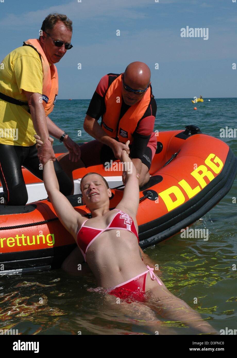 (dpa) - DLRG (German life saving federation) lifeguards demonstrate saving a swimmer during an emergency drill on the beach of Baltic Sea resort Binz, Germany, 1 August 2004. Research results in 2004 showed that a fourth of the German population aged over 14 can only swim very badly or not at all. The DLRG therefore calls for cities to avoid closing down public pools and provide mo Stock Photo