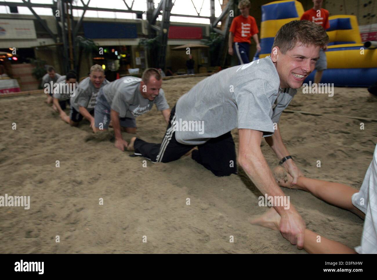 (dpa) - German cyclist Jan Ullrich and his teammates of team T-Mobile are crawling over a beach volleyball field in Amsterdam, Netherlands, 21 November 2004. In the background Germans Stephan Schreck and Eric Baumann, and Spaniard Oscar Sevilla (from front to back). The traditional meeting of team T-Mobile takes place in the Netherlands. Stock Photo